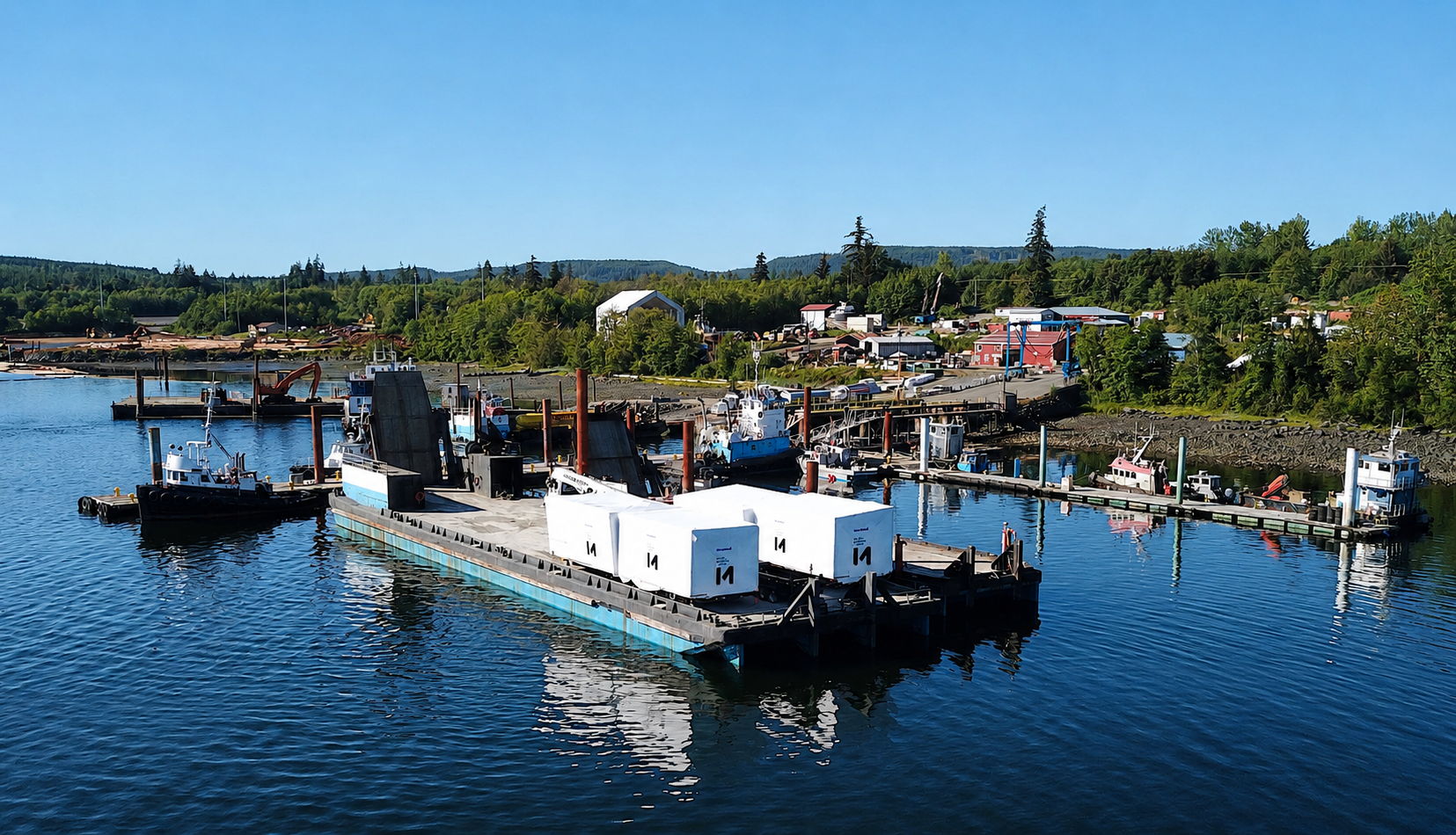 Four completed modular building modules being transported by barge along the BC coast to Cortez Island